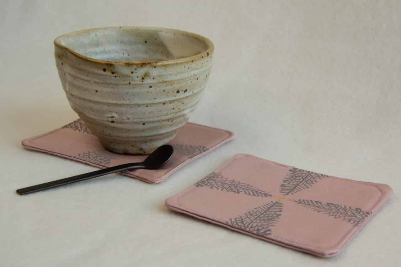 Ceramic tea cup on a pink coaster