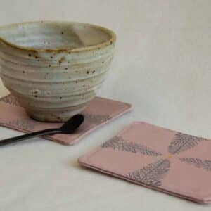 Ceramic tea cup on a pink coaster