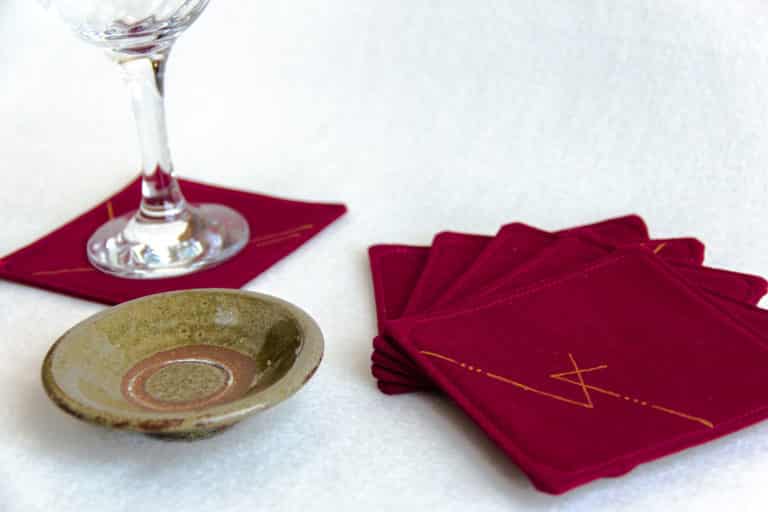 Six burgundy coasters with a wine glass and small dish