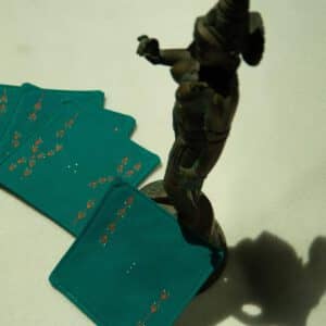 Set of four coasters arranged next to a metal statue