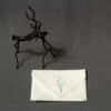 A folded handkerchief with a hand-painted floral design next to a small statue of a horse