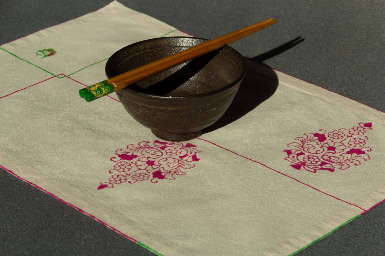 Single placemat with a ceramic bowl and chopsticks on top