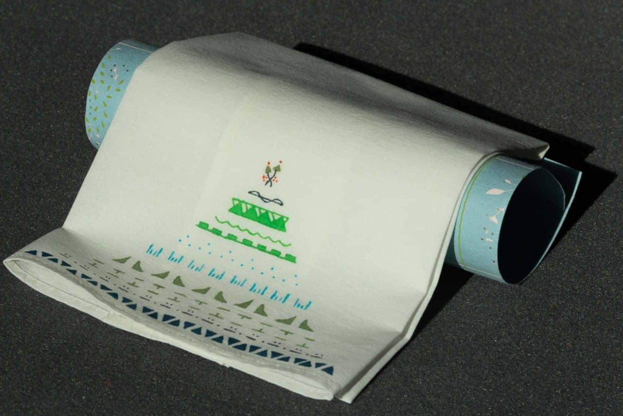 A folded handkerchief draped over a roll of gift-wrapping paper