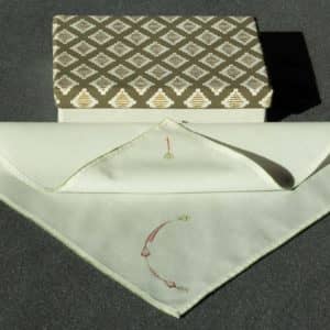 A partially folded handkerchief and an ornamental box