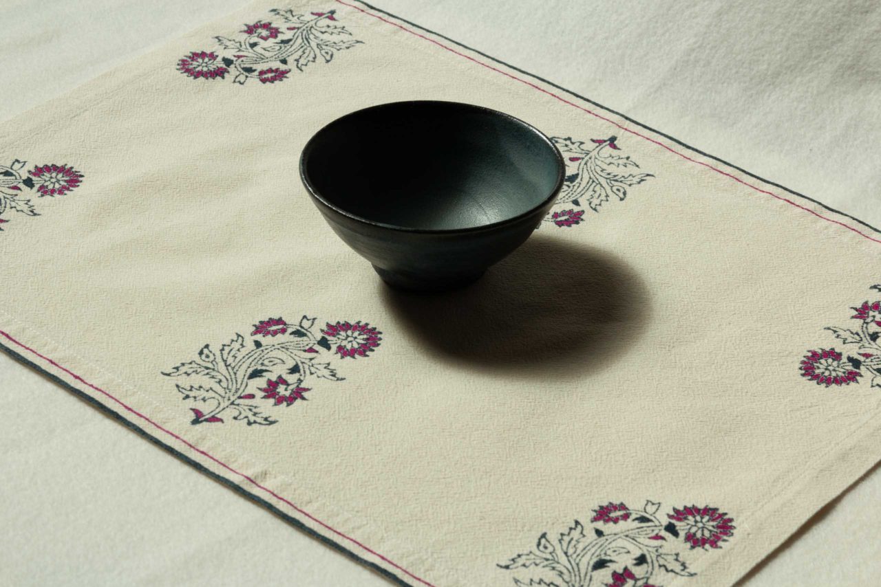 A single placemat with a bowl in the middle