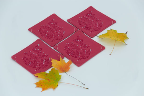 Four coasters and maple leaves.