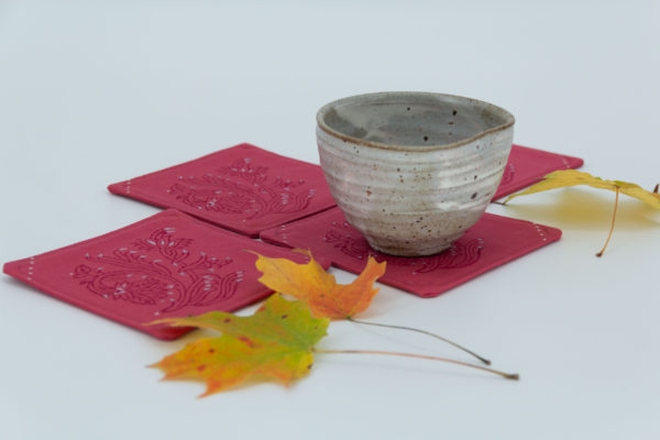 Four coasters with a ceramic cup and maple leaves