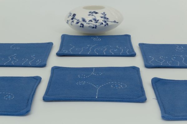 Two blue and white coasters with a ceramic cup.