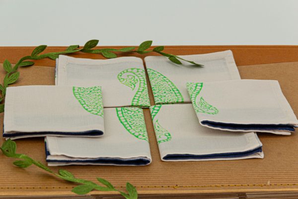 Six folded napkins on a book surface and a decorative ribbon