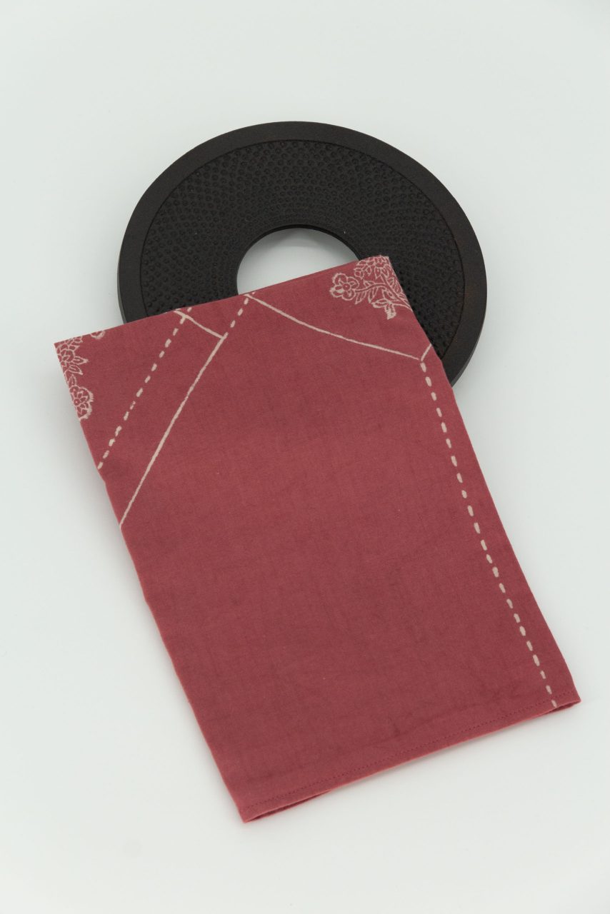 A folded handkerchief on a cast iron trivet