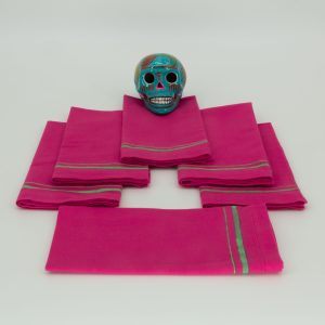 Six folded napkins with a ceramic Mexican decorative skull