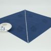 A single napkin with a small ceramic dish on the side