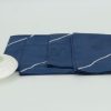 Four folded napkins with a small ceramic dish