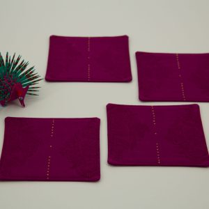 Four coasters next to a small figurine of a porcupine