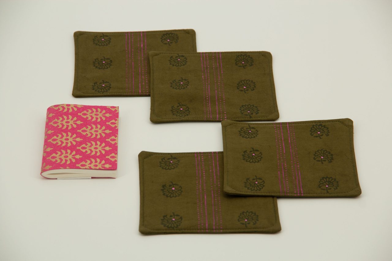 Four coasters next to a small notebook