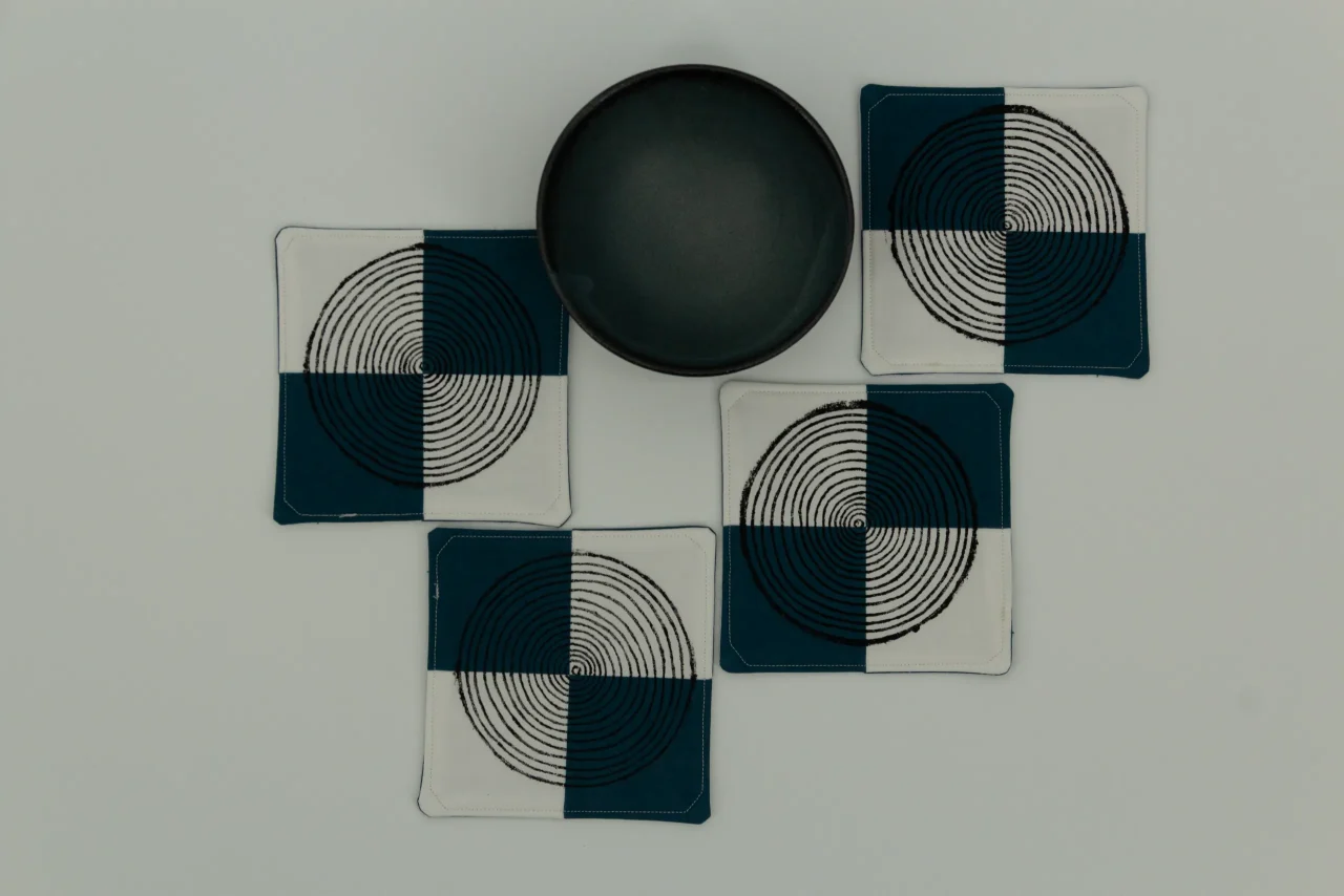 Four coasters next to a small ceramic bowl