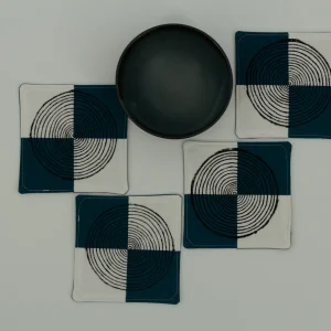 Four coasters next to a small ceramic bowl