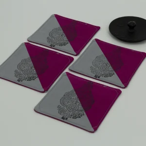 Four coasters next to the lid of an iron kettle